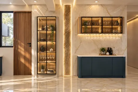 Bar wall, Gulmohar House. Glass cabinets lit from inside, a stone pilaster lit along both edges, and a deep blue counter under gold-veined marble.